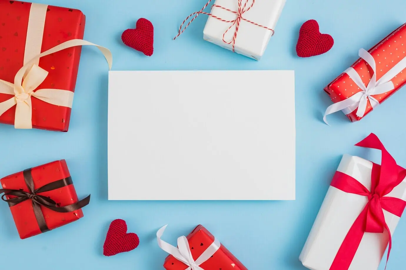 Valentinstags-Geschenkboxen und Herzen um ein Blatt Papier herum.