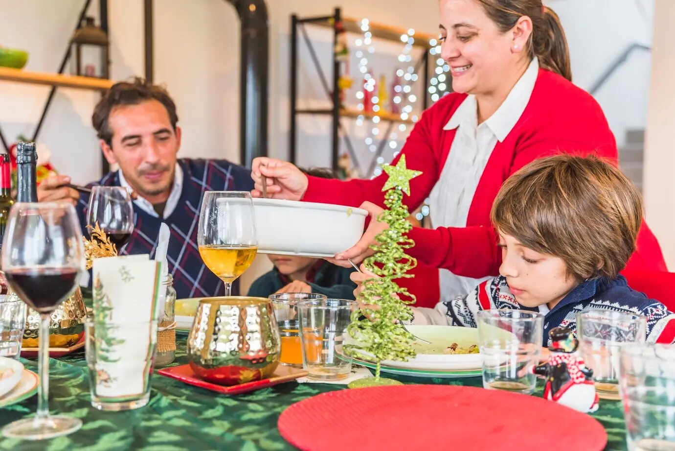 Eine Frau in Rot legt Essen auf Teller.